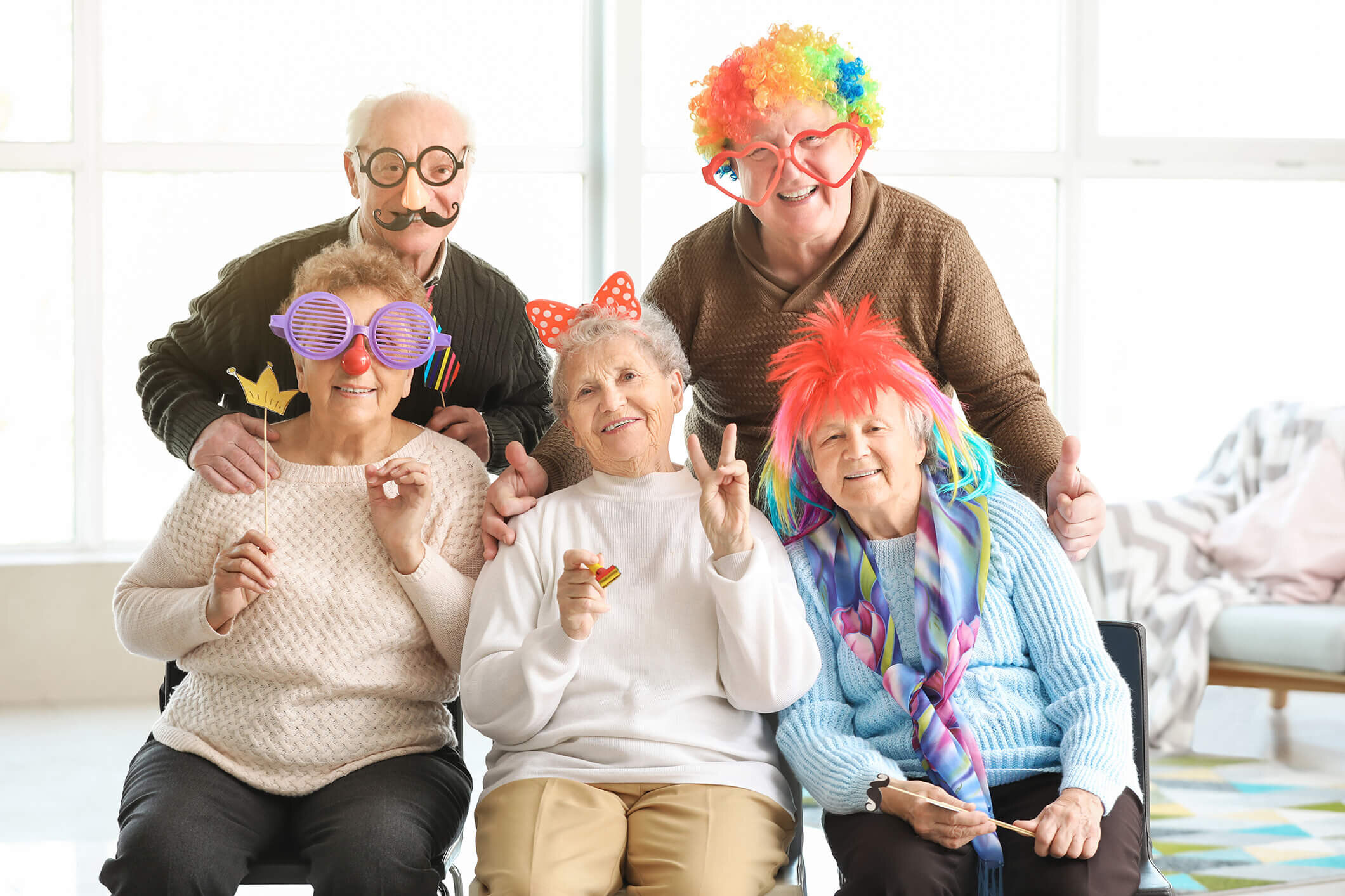 Residents laughing together in party glasses and wigs